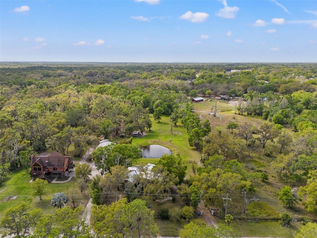 drone / aerial view with a forest view and a water view