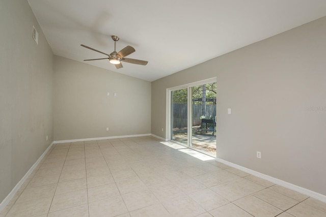 spare room featuring lofted ceiling, light tile patterned floors, a ceiling fan, and baseboards