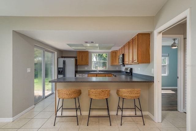 kitchen featuring dark countertops, visible vents, brown cabinets, and appliances with stainless steel finishes