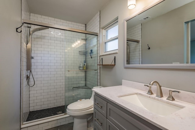 bathroom featuring visible vents, toilet, a stall shower, and vanity