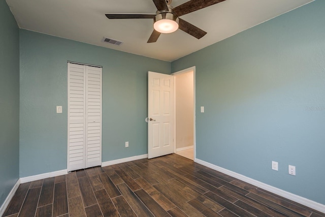 unfurnished bedroom featuring a closet, visible vents, baseboards, and wood finished floors