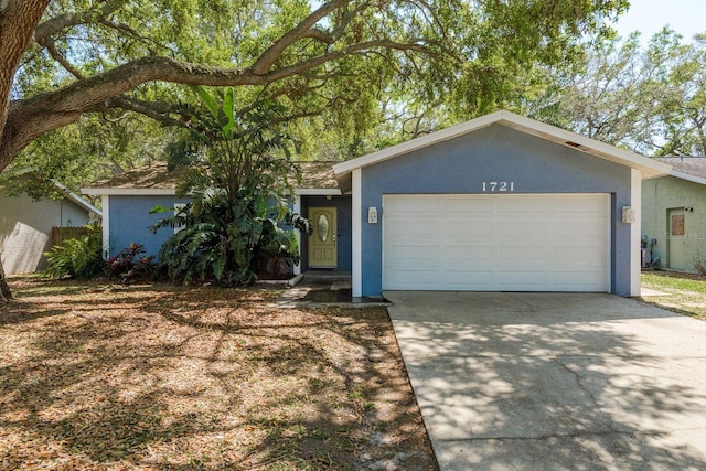 ranch-style home featuring stucco siding, concrete driveway, and an attached garage