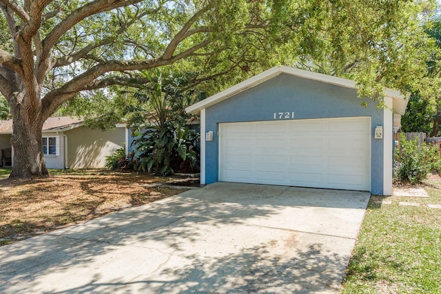 view of front of property with a garage, stucco siding, and an outdoor structure