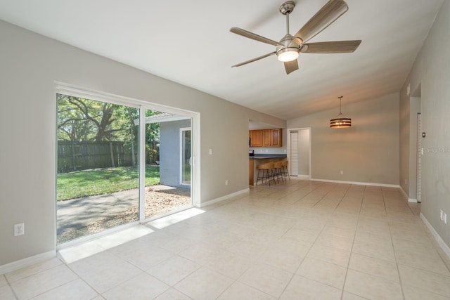 unfurnished living room featuring baseboards, a ceiling fan, and vaulted ceiling