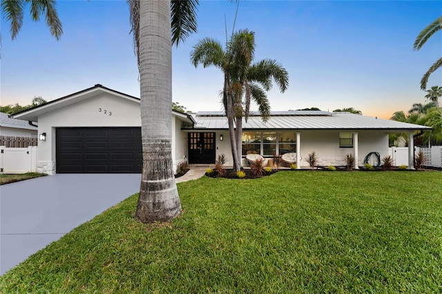 view of front facade featuring a front yard, fence, a garage, and stucco siding