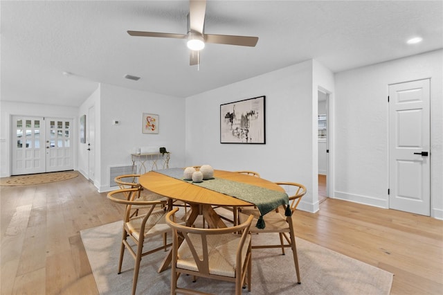 dining room featuring visible vents, light wood-type flooring, and baseboards