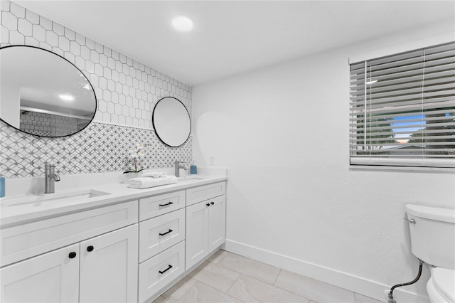 full bath featuring decorative backsplash, toilet, baseboards, and a sink