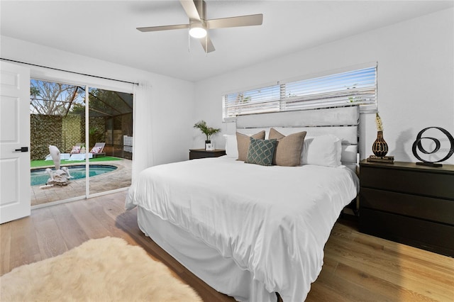 bedroom featuring access to exterior, multiple windows, wood finished floors, and ceiling fan