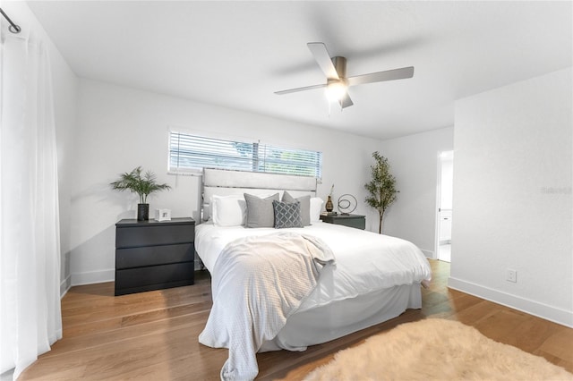 bedroom with a ceiling fan, baseboards, and wood finished floors