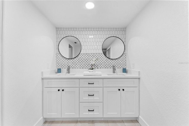 full bathroom with double vanity, baseboards, and a sink