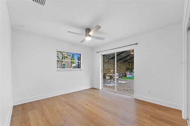 unfurnished room with visible vents, light wood-style floors, baseboards, and ceiling fan