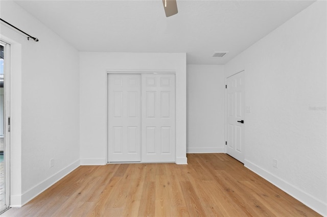 unfurnished bedroom featuring light wood-style floors, visible vents, a closet, and baseboards