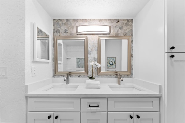 bathroom with a sink, a textured ceiling, and double vanity