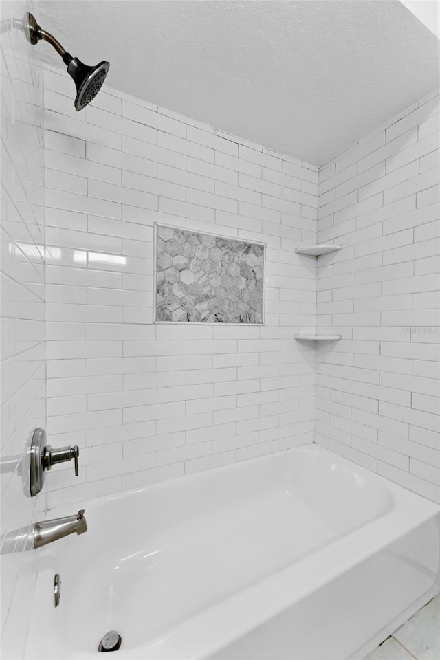 full bath with a textured ceiling and shower / bathtub combination