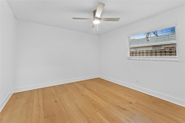 spare room featuring light wood-style floors, baseboards, and ceiling fan