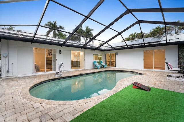 pool featuring glass enclosure and a patio area