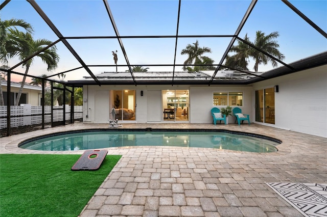 outdoor pool with glass enclosure and a patio area