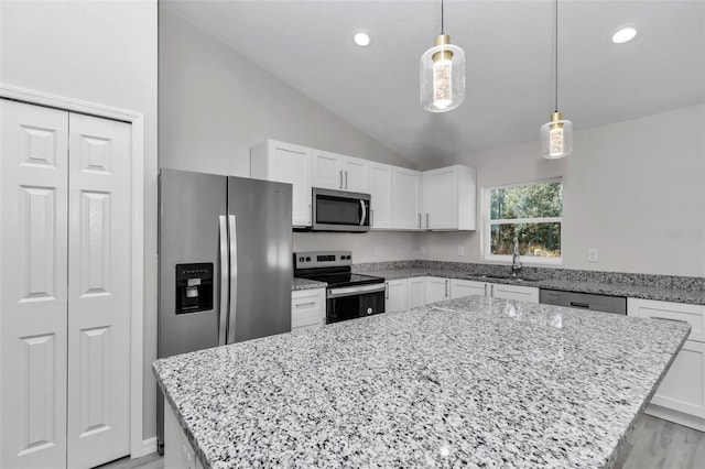 kitchen featuring a sink, stainless steel appliances, light stone counters, and vaulted ceiling