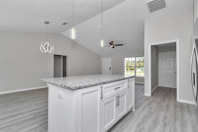 kitchen featuring vaulted ceiling, white cabinets, light wood-style flooring, and visible vents