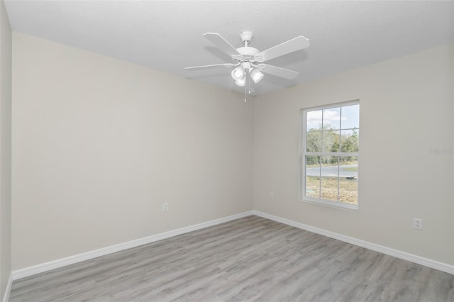 unfurnished room with light wood-type flooring, baseboards, and a ceiling fan