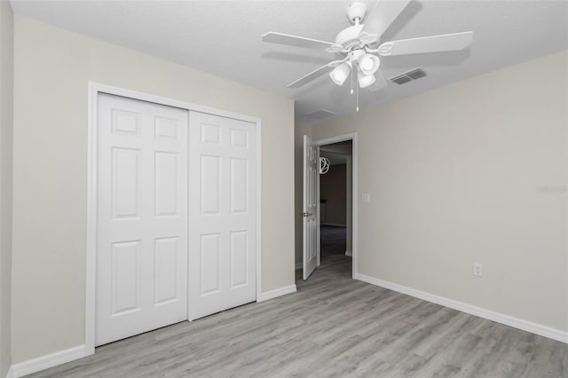 unfurnished bedroom with visible vents, baseboards, ceiling fan, light wood-style flooring, and a closet