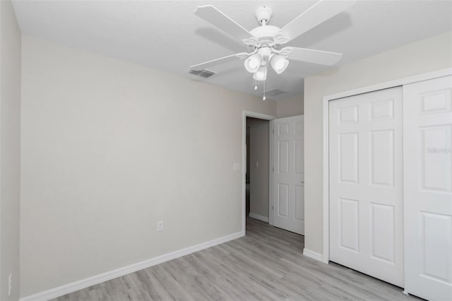 unfurnished bedroom with baseboards, visible vents, ceiling fan, a closet, and light wood-type flooring