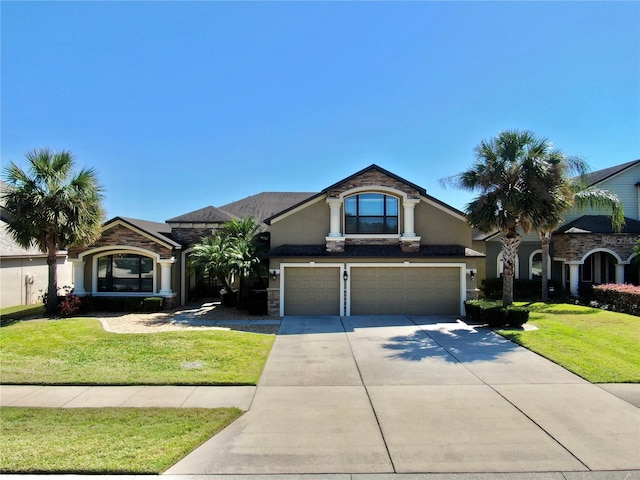 french provincial home featuring a front yard, stucco siding, concrete driveway, a garage, and stone siding