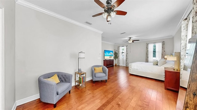 bedroom with baseboards, a ceiling fan, light wood-style floors, and ornamental molding