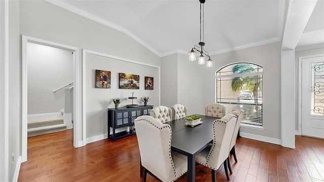 dining area featuring baseboards, lofted ceiling, dark wood-style floors, and crown molding