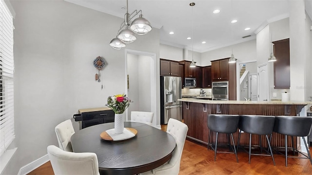 dining area with recessed lighting, light wood-style floors, baseboards, and ornamental molding