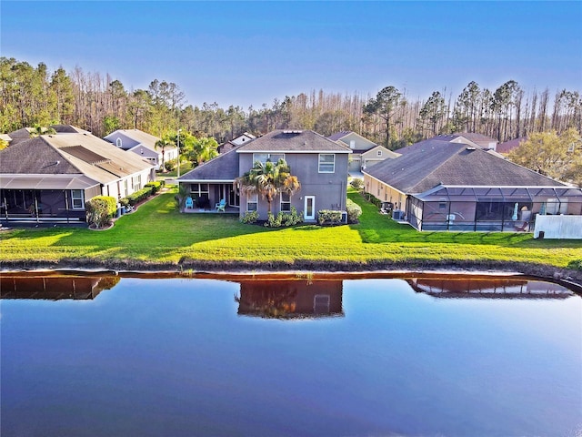 back of house with a yard and a water view