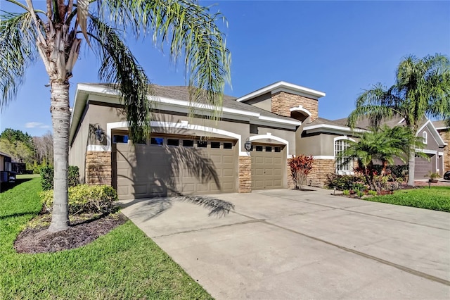 view of front of home with stone siding, stucco siding, an attached garage, and driveway