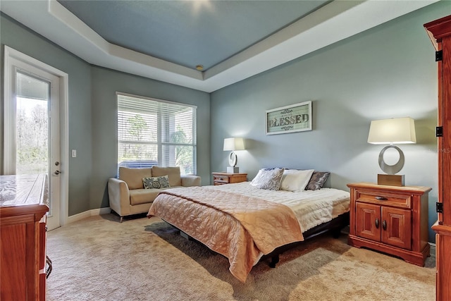 bedroom with access to exterior, a raised ceiling, light colored carpet, and baseboards