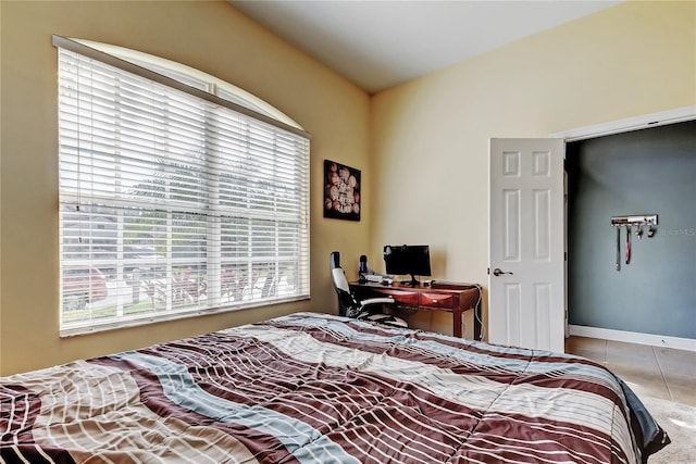 tiled bedroom featuring baseboards and lofted ceiling