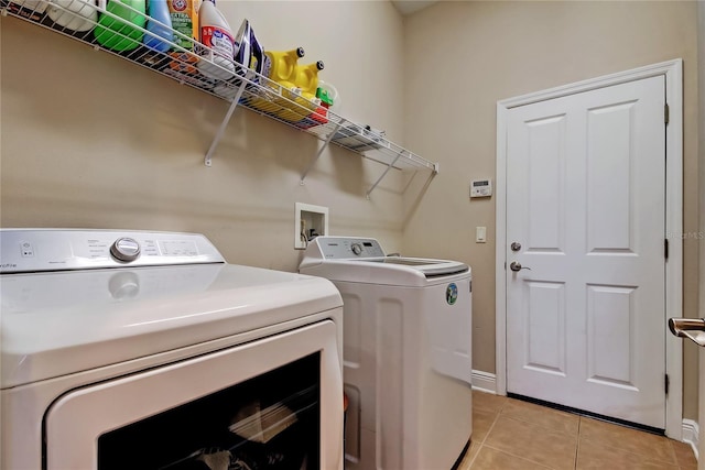 laundry room with light tile patterned flooring, laundry area, and separate washer and dryer