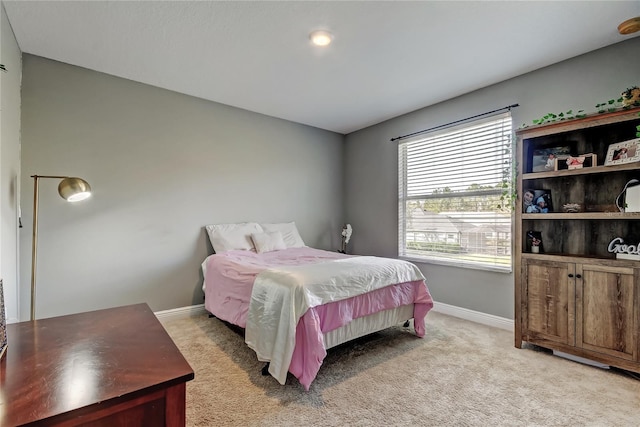 bedroom with light carpet and baseboards