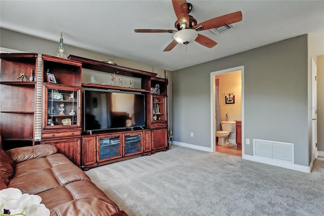 living room featuring visible vents, baseboards, light colored carpet, and a ceiling fan