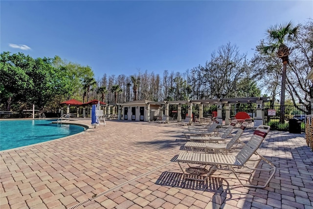 pool with a patio and fence