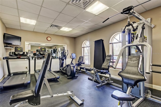 exercise room featuring baseboards, visible vents, and a drop ceiling