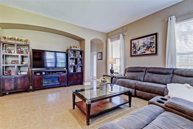 living room featuring light tile patterned floors and arched walkways