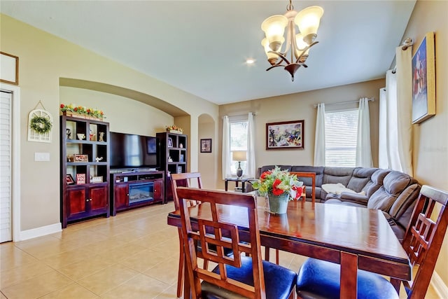 dining area featuring light tile patterned flooring and an inviting chandelier