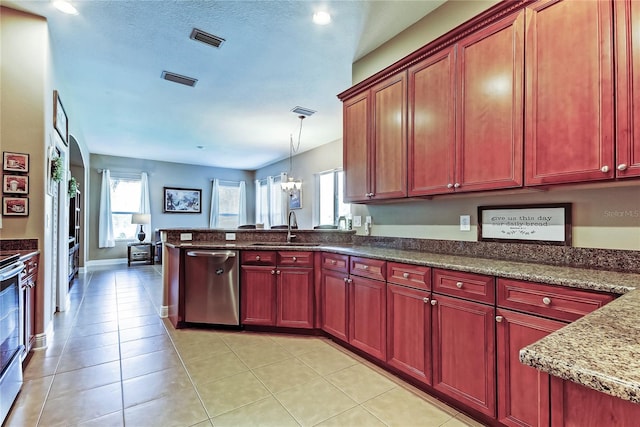 kitchen with visible vents, dark brown cabinets, a peninsula, stainless steel appliances, and a sink