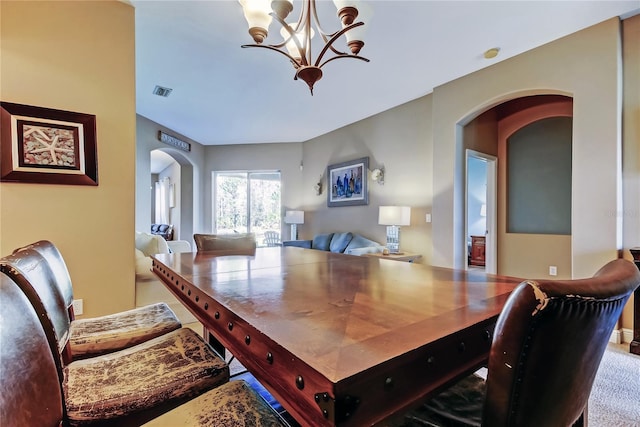 dining area with visible vents, arched walkways, and a chandelier