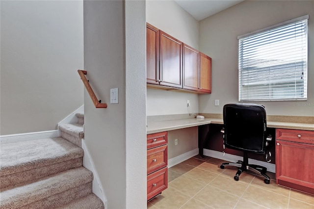 office space with light tile patterned floors, baseboards, and built in study area