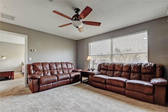 carpeted living area with visible vents and ceiling fan