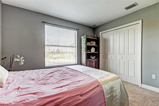 bedroom featuring a closet, baseboards, visible vents, and carpet floors