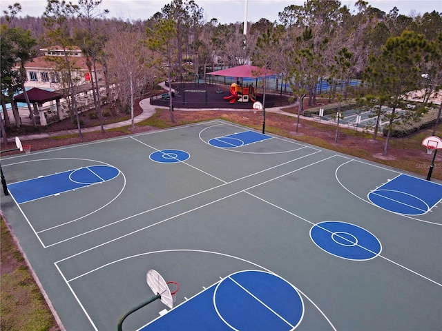 view of basketball court with playground community, community basketball court, and fence