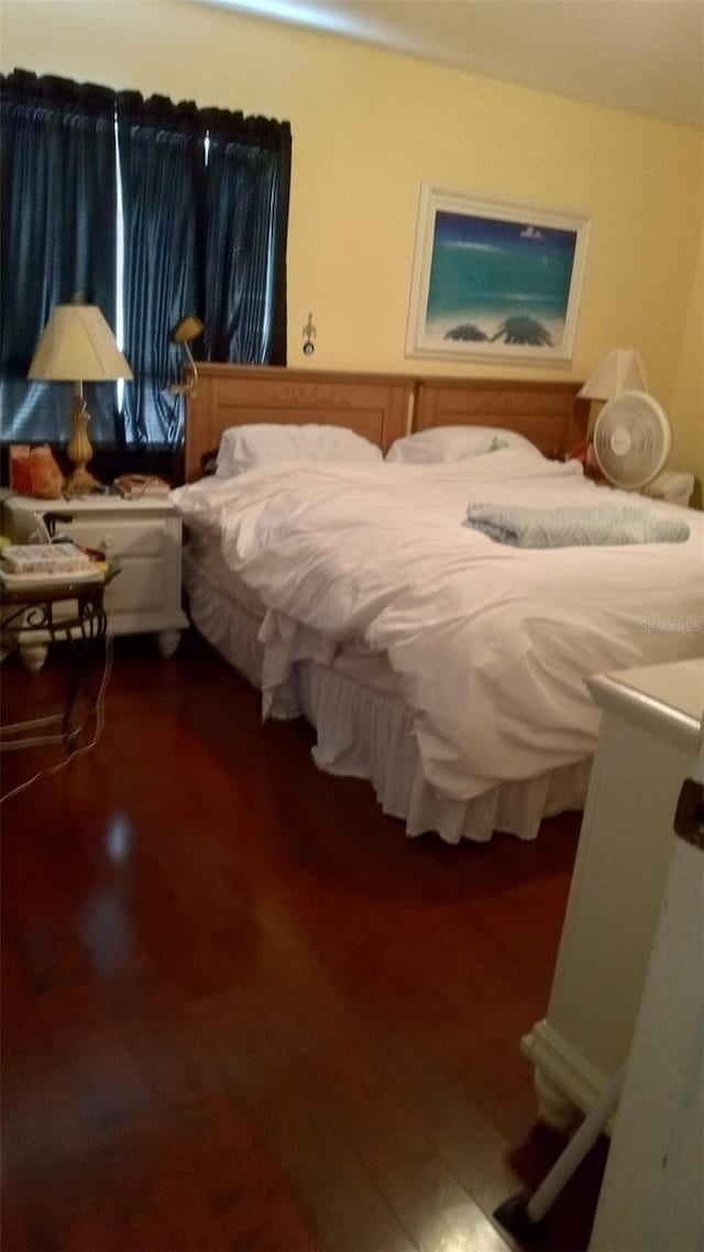 bedroom with dark wood-type flooring