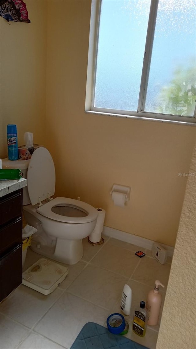 bathroom with baseboards, toilet, vanity, and tile patterned flooring