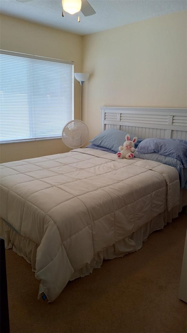 bedroom featuring a ceiling fan and carpet